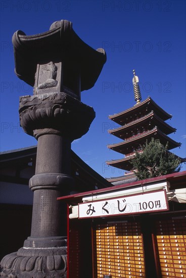JAPAN, Honshu, Tokyo, Asakusa. Senso Ji Temple. Angled view of the Five Storey Pagoda with ornamental column and other buildings in the foreground