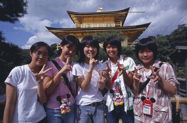 JAPAN, Honshu, Kyoto, Group of teenage girls standing in front of the Kinkaku Ji aka Golden Pavilion