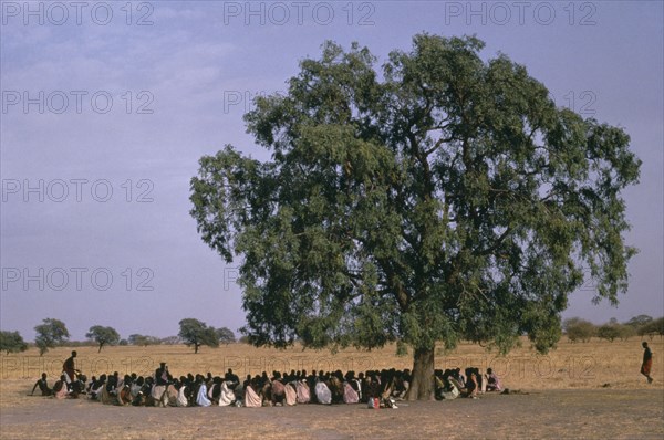 SUDAN, General, Shilluk tribespeople gathered under a tree in the shade for story telling