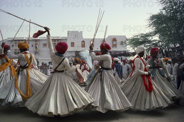INDIA, Rajasthan, Jodhpur, Men in traditional clothes performing dance for the Maharaja of Jodhpur in a Thakurs courtyard.