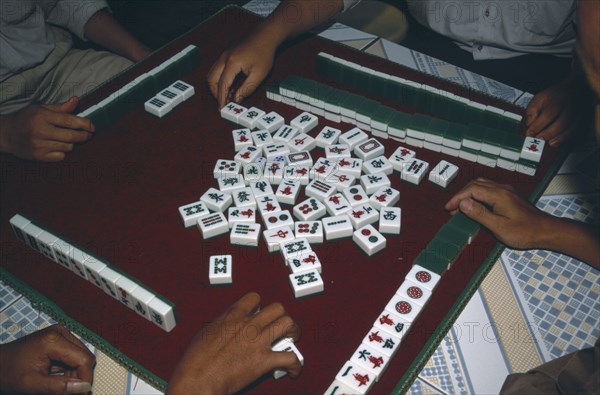 CHINA, Yunnan, Mah Jong game being played with view over peoples hands on a tiled table.