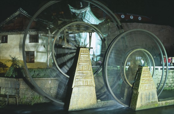 CHINA, Yunnan, Lijiang, Waterwheel at night.