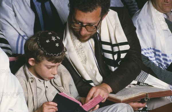 ENGLAND, Religion, Judaism, Jewish father and son attending preparation for Bar Mitzwah in synagogue.