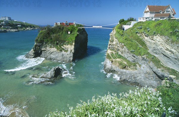 ENGLAND, Cornwall, Newquay, The House in The Sea. Small house atop rock island joined to the mainland by a bridge with the sea below