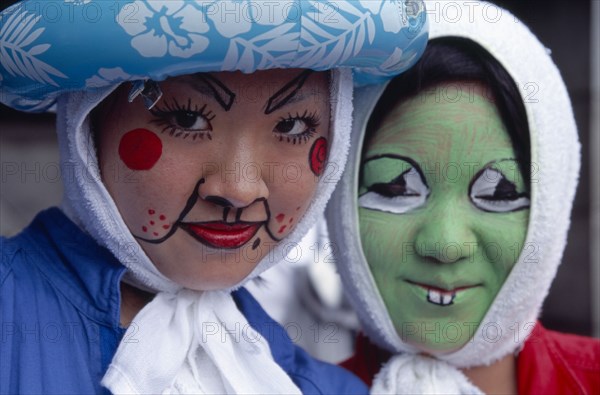 JAPAN, Honshu, Tokyo, Harajuku District. Portrait of two girls smiling wearing face paint