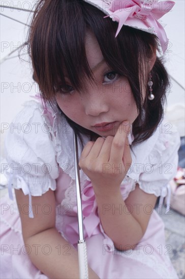 JAPAN, Honshu, Tokyo, Harajuku District. Portrait of young teenage girl wearing pink and white dress