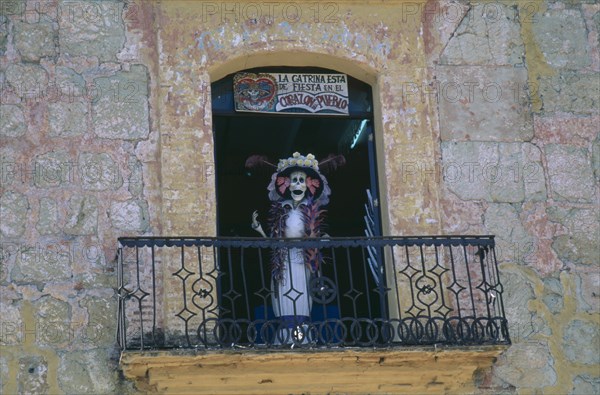 MEXICO, Oaxaca, Skeleton figure on shop window balcony for Day of the Dead.