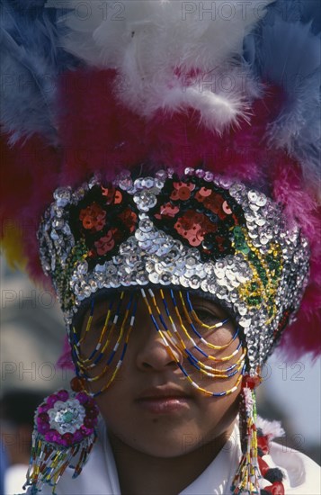 MEXICO, Mexico City, Portrait of dancer wearing feathered head dress celebratiing festival of Our Lady of Guadaloupe.