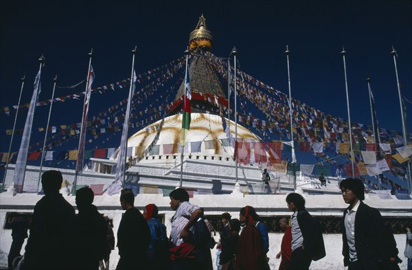 NEPAL, Bodhanath, "Pilgrims circling clockwise around Bodhanath Stupa draped with prayer flags during Loshar, the Tibetan New Year"