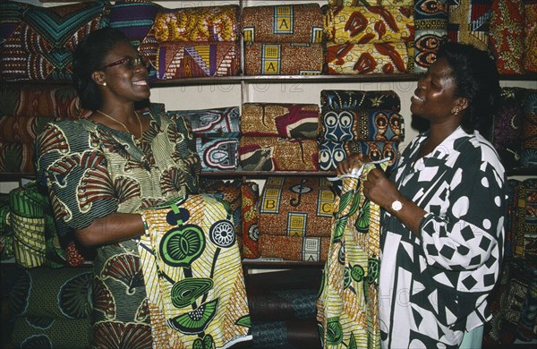 TOGO, Lome, Female cloth vendors selling traditional cloth at market.