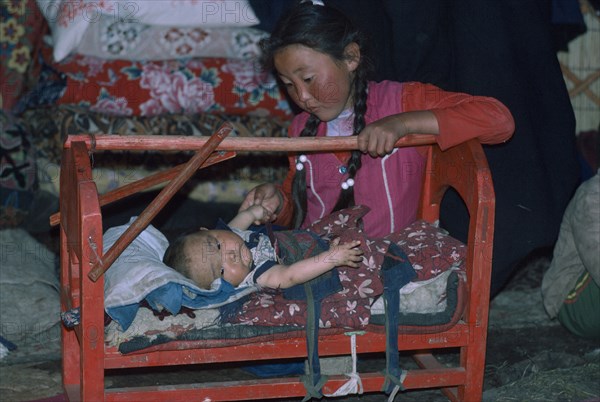 CHINA, Xinjiang Province, Altai Mountains, Kazakh siblings inside kigizuy.