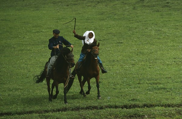 CHINA, Xinjiang Province, Tribal People, Kazakh traditional race on horseback called Kuuz Kuu or Catch the Girl.  The girl may whip the boy chasing her but if successful in catching her he earns a kiss.