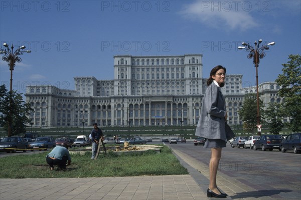 ROMANIA, Bucharest, House of the Republic.  Palace of former Communist president Nicholae Ceausescu.  Exterior facade with young woman standing in foreground.
