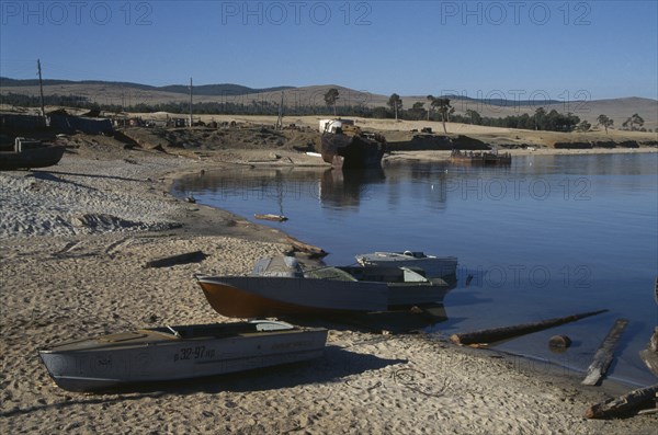 RUSSIA, Siberia, Lake Baikal, Fishing boats pulled up on lake shore.