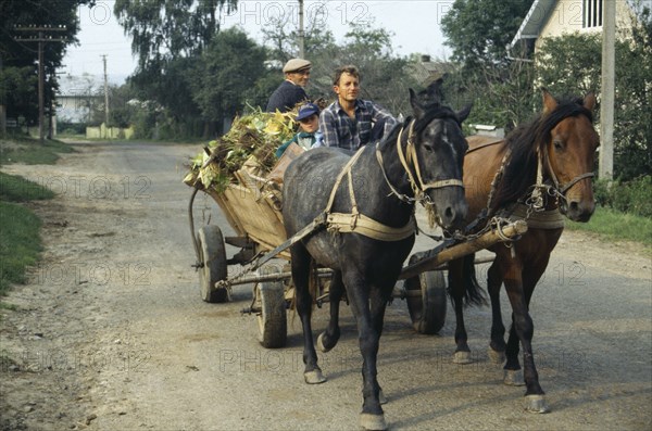 UKRAINE, Ivano Frankivsk, Men and child in horse drawn wooden cart.