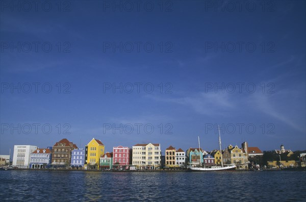 WEST INDIES, Dutch Antilles, Curacao, Willemstad.  Colourful waterfront buildings and moored sailing ship.