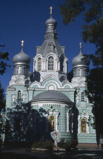 UKRAINE, Odessa, Pale green and white painted exterior facade of Ukrainian Orthodox Church with onion dome rooftops.