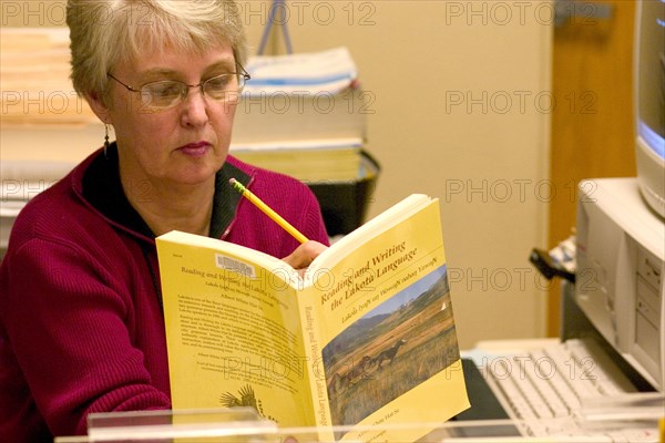 USA, Minnesota, Minneapolis, Librarian at the Franklin Public Library finding a reference in the Lakota Language textbook.