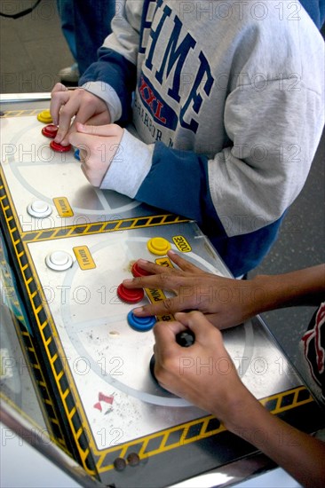 USA, Minnesota, St Paul, Hands of players age 10 intently playing a video game during a Youth Express activity for inner city youths