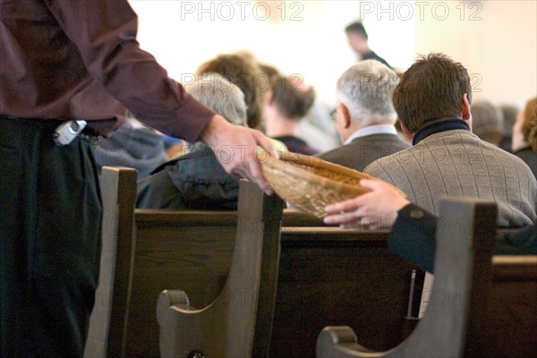 USA, Minnesota, St Paul, Passing offering basket at church.