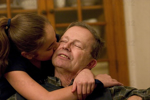 USA, Minnesota, St Paul, Grandaughter hugging and kissing her grandfather on the cheek