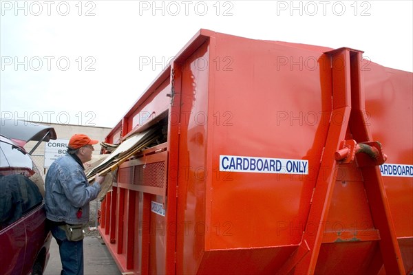 USA, Minnesota, St Paul, Recycling cardboard in a large orange dumpster at Vasko Disposal Solutions.