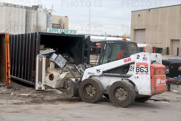 USA, Minnesota, St Paul, Bobcat a front end loader removing items from the appliance bin in the Vasko Disposal Solutions junk yard.