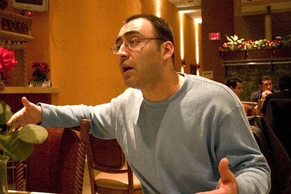 USA, Minnesota, Minneapolis, Impassioned young man talking in a restaurant.