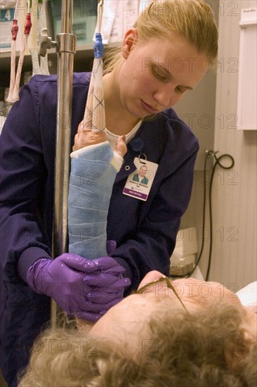USA, Minnesota, Plymouth, Clinic nurse forming cast on arm of elderly patient with broken wrist.