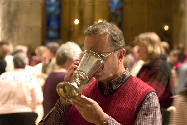 USA, Minnesota, Minneapolis, Catholic Parishioner sipping wine from chalice during communi at the Christmas Pageant in the Basilica of St Mary.