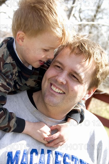 USA, Minnesota, Clitherall, Son talking to dad with arms around his neck.