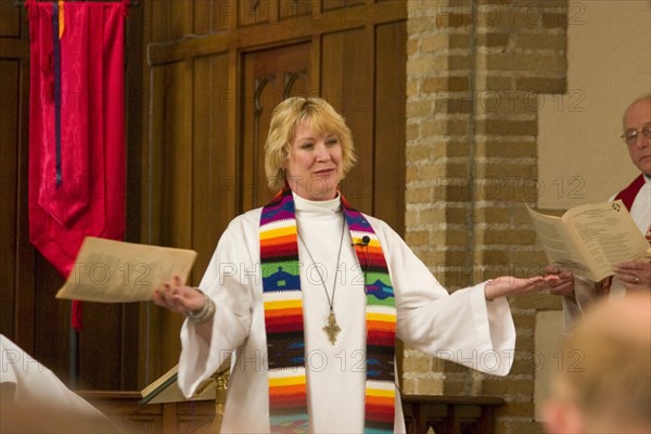 USA, Minnesota, Minneapolis , Pastor greeting the congregation while officiating at an ordination in the sanctuary of Grace University Lutheran Church.