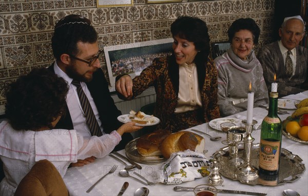 ENGLAND, Religion, Judaism, Jewish New Year.  The chala or bread is passed along table during festival meal in family home.