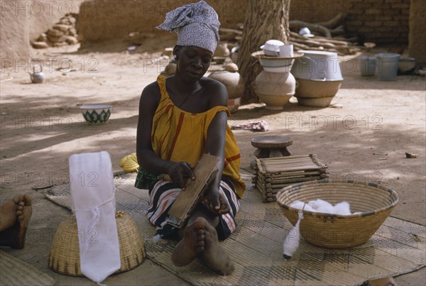 MALI, Industry, Work, Woman carding cotton before spinning into thread.