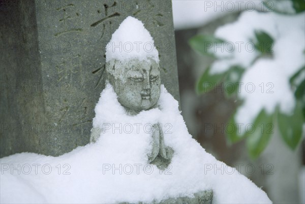 JAPAN, Fukui, Obama, Zen Buddhist grave and statue in snow.