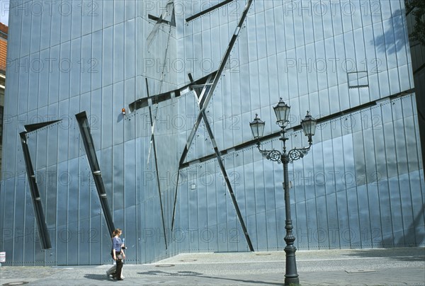 GERMANY, Berlin, Visitors walking past the zinc clad facade of the Jewish Museum designed by Polish architect Daniel Libeskind in 1998 and opened in 2001.