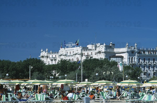ITALY, Emilia-Romagna, Rimini, "The Grand Hotel with busy beach, parasols and sun loungers in the foreground. "