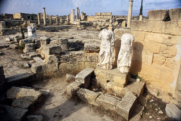 LIBYA, Cyrenaica, Cyrene, Agora.  Ruins of public square with two decapitated and armless statues in the foreground.