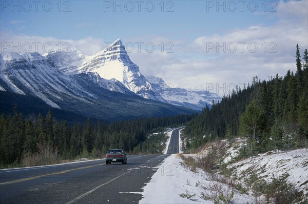 CANADA, Alberta, Banff National Park , Car on Trans-Canada highway through snow covered landscape.