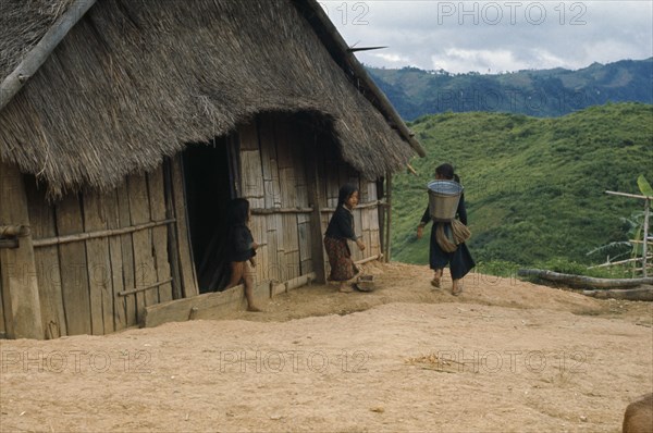 LAOS, Traditional Housing, Meo children outside thatched house in village near Luang Prabang.