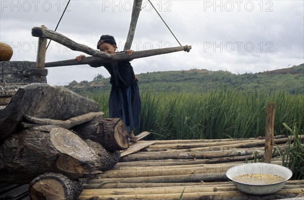 LAOS, Work, Meo girl grinding flour in village near Luang Prabang.