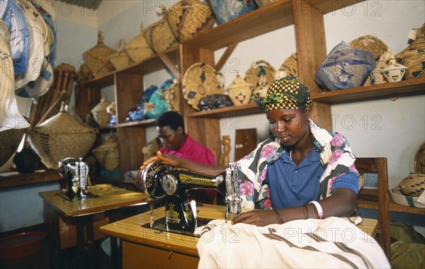 TANZANIA, West, Great Lakes Region, Women using sewing machines in dressmaking workshop in refugee camp.