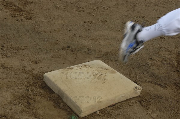 JAPAN, Chiba, Tako, Little league players foot rounds first base during practice at Toujou Shonen Yakyu baseball Club practice.