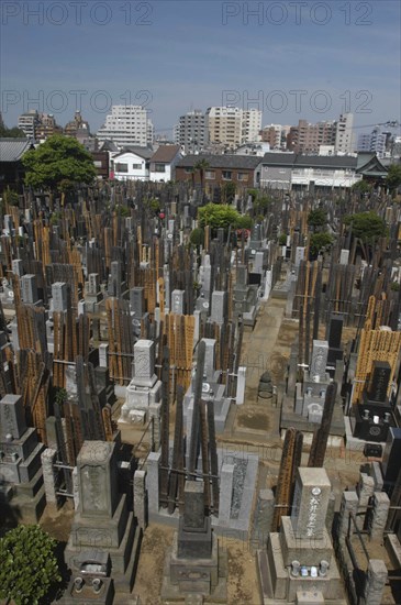 JAPAN, Tokyo, Yanaka. View over the cemetary of Shoyomei-ji Temple with closely surrounding buildings beyond