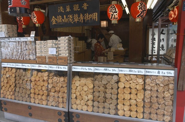 JAPAN, Honshu, Tokyo, "Asakusa. Nakamise-dori leading to Senso-ji temple, a traditional  ""Sembei"" grilled rice cracker shop displays wares"