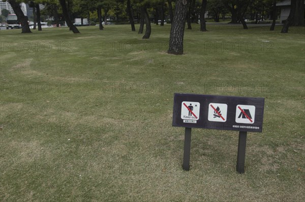 JAPAN, Honshu, Tokyo, "Sign on park grass between Hibiya and Nijubashi prohibiting walking on grass, fires, and camping. Aimed at homeless people"
