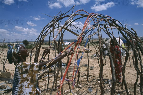 SOMALILAND, Hargeisa, Women building frame of traditional nomadic house in Kandahr IDP camp.