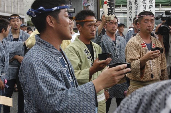 JAPAN, Chiba, Narita, Gion Matsuri with men in  traditional Edo-era costumes toasting each other with sake