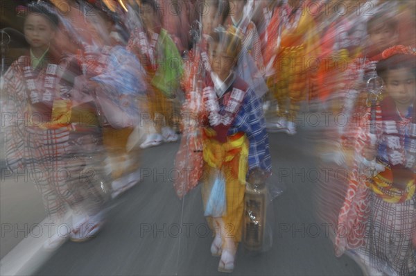 JAPAN, Chiba, Narita, "8 year old Maki Tsuchiya leads her neighborhood tekomae, girls that walk before the Dashi or wagon during Gion Matsuri wearing traditional Edo-era costume  Radial Blur."