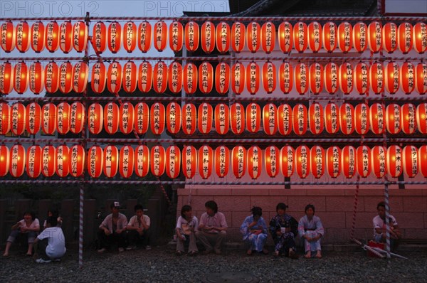 JAPAN, Chiba, Narita, Festival goers at the Gion Matsuri rest under rows of illuminated chochin lanterns with name of donor to Narita san Temple written on each